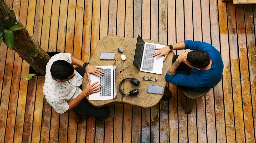Δύο άνδρες που εργάζονται στα λάπτοπ τους