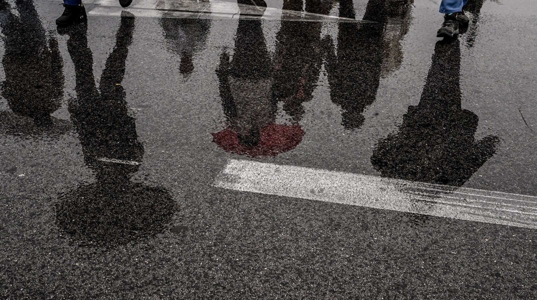 Αντικατοπτρισμός με ομπρέλες εν μέσω βροχής σε λίμνη νερού