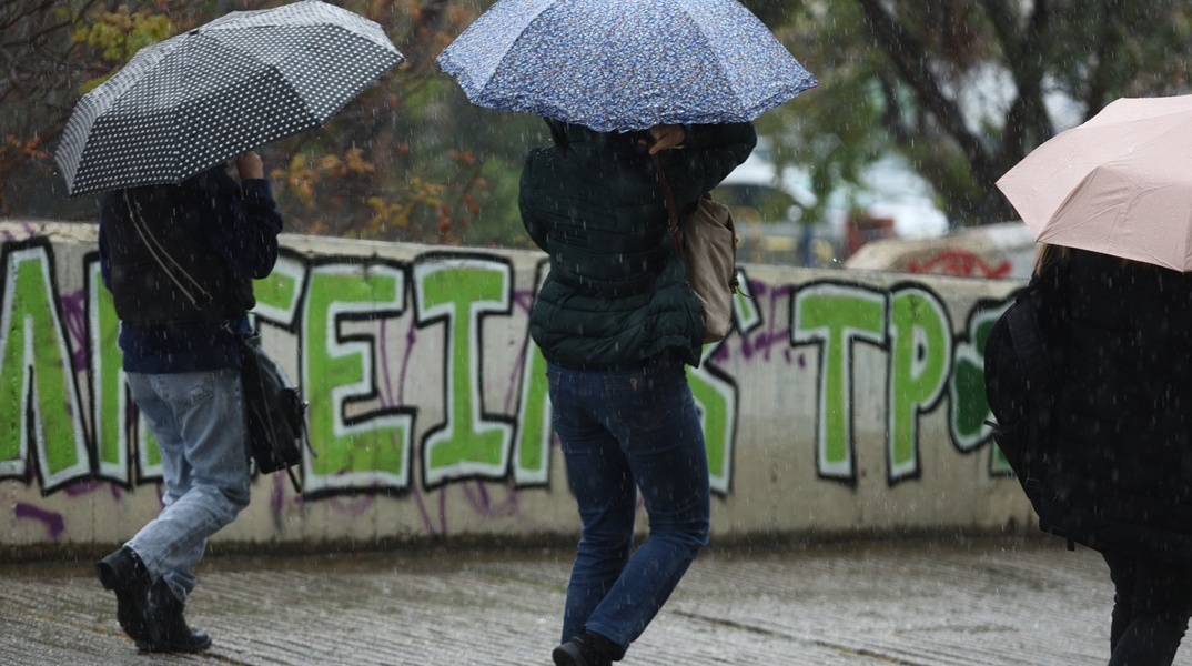 Άτομα με ομπρέλες εν μέσω βροχής
