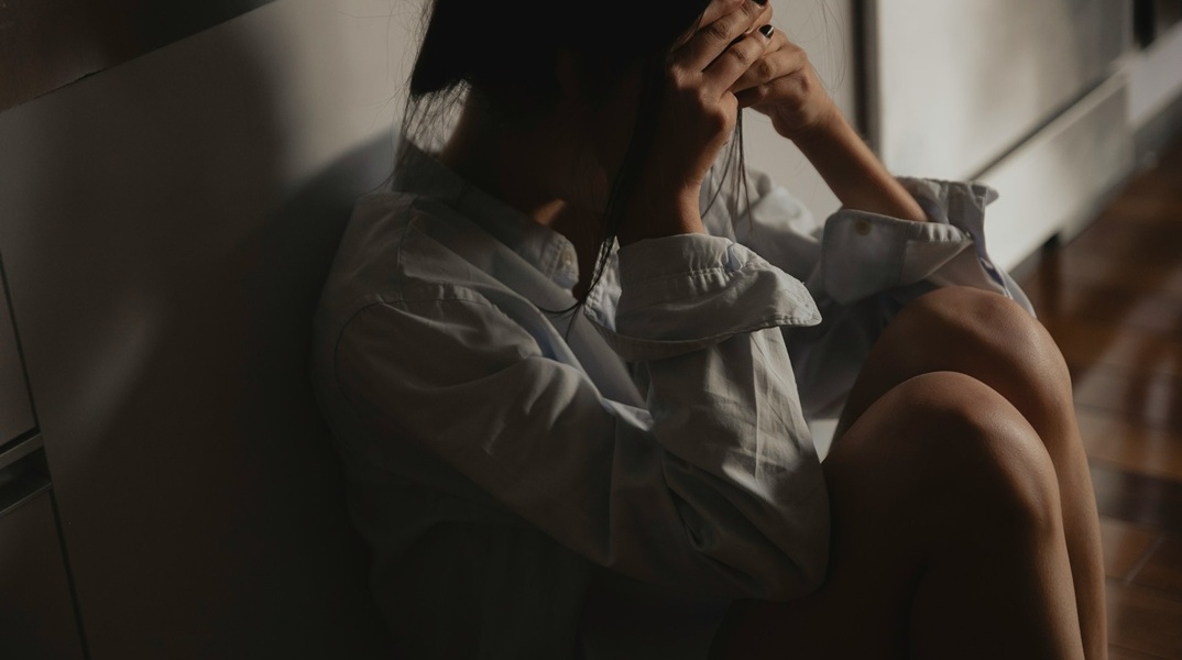 Γυναίκα κρύβει το πρόσωπό της