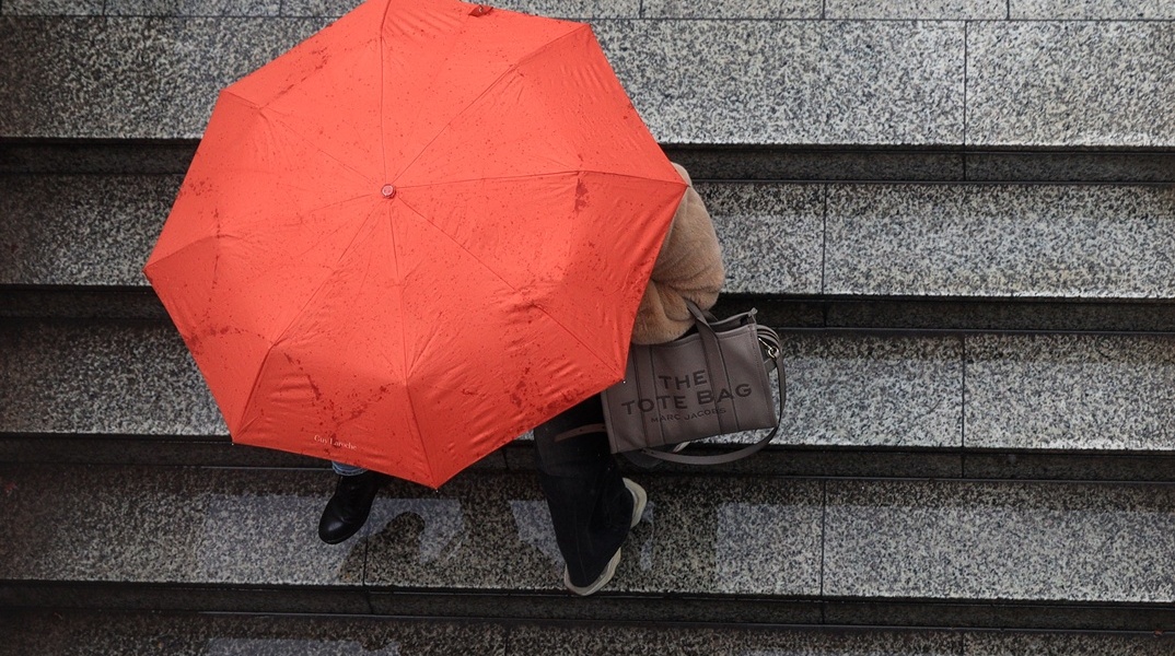 Γυναίκα με ομπρέλα εν μέσω καταιγίδας