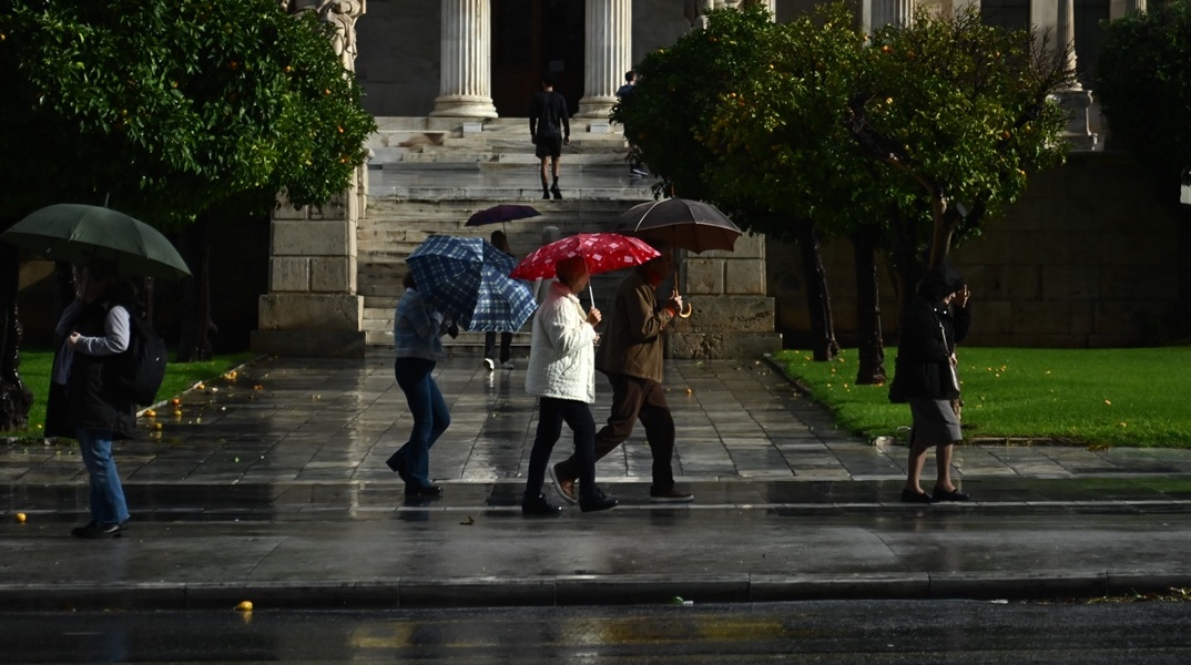 Πολίτες με ομπρέλες στο κέντρο της Αθήνας