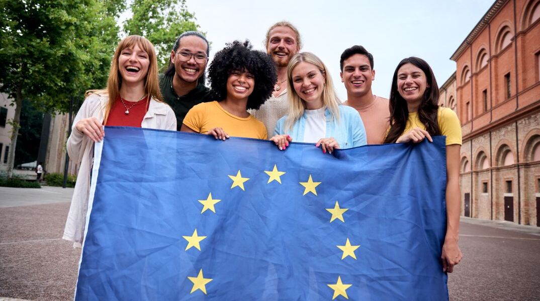 Παρέα νέων που κρατούν τη σημαία της ΕΕ