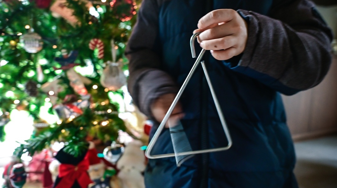 Παιδί με τρίγωνο λέει τα κάλαντα