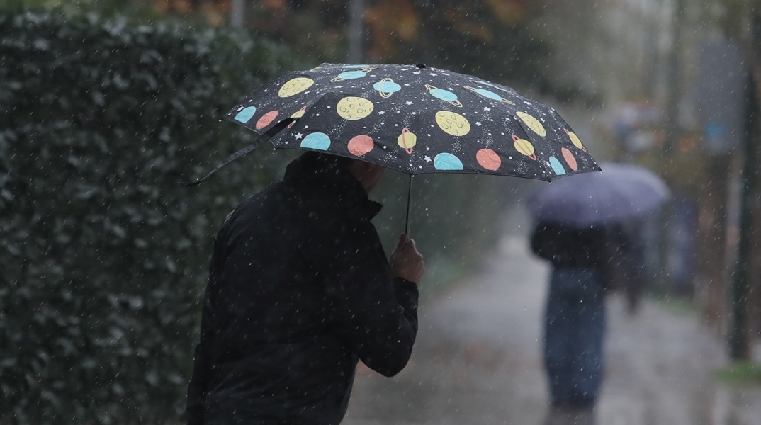 Άτομο με ομπρέλα εν μέσω βροχής