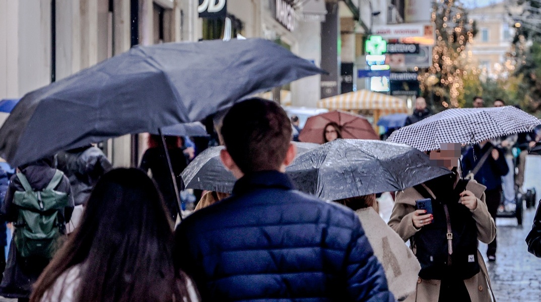 Πολίτες με ομπρέλες στην Αθήνα
