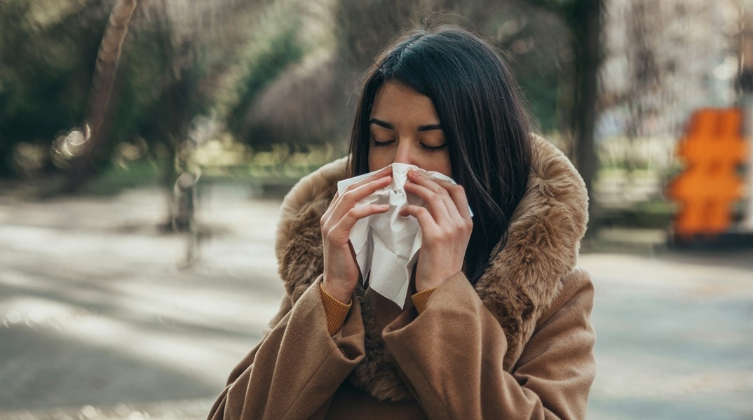 Άτομο που σκουπίζει τη μύτη του με χαρτομάντηλο