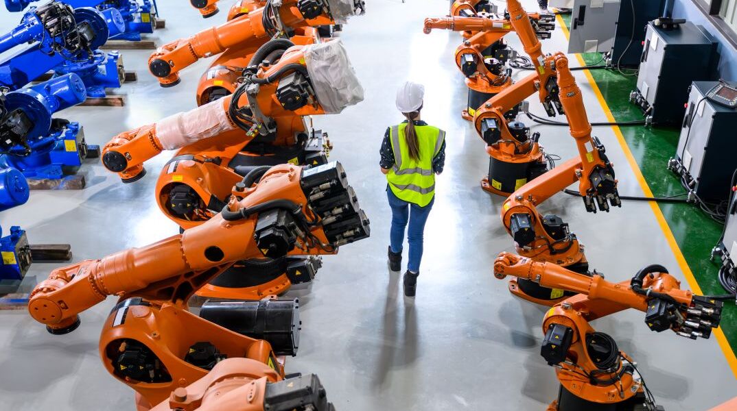 Ρομπότ και εργαζόμενη σε μια βιομηχανική μονάδα