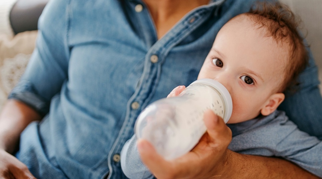 Μωρό που πίνει γάλα με μπιμπερό
