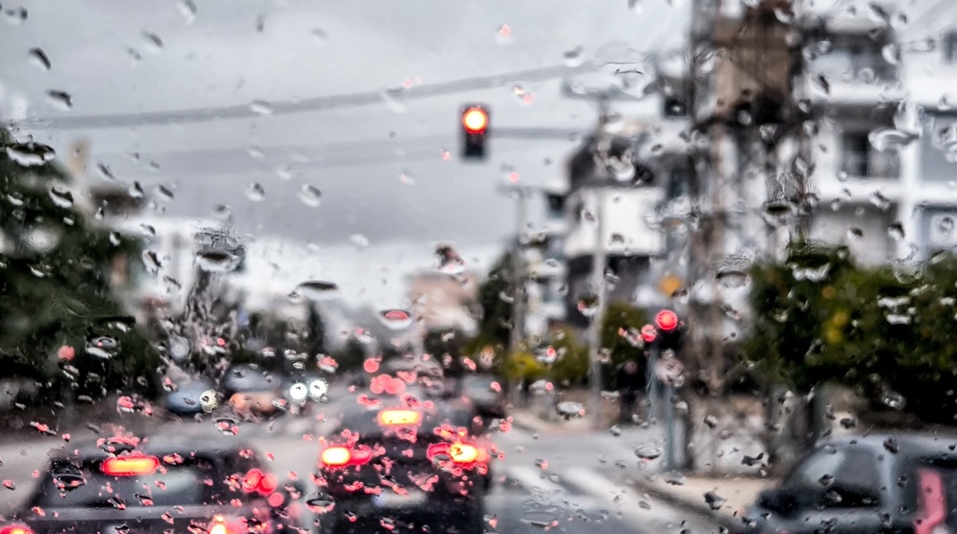 Σταγόνες βροχής στο παρμπρίζ αυτοκίνητου ενώ μέσω καταιγίδας