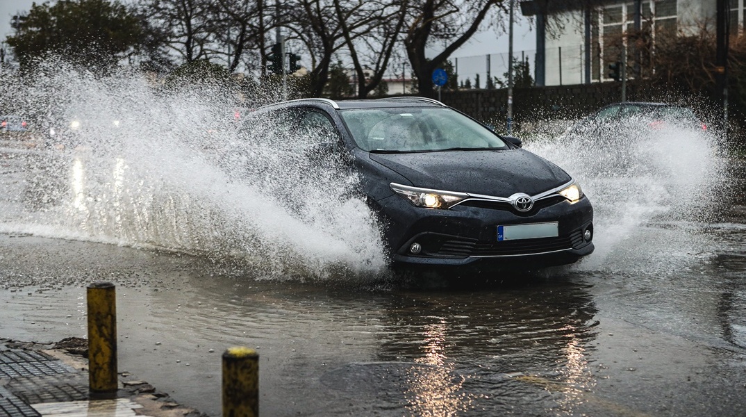 Αυτοκίνητο σε πλημμυρισμένο δρόμο εν μέσω καταιγίδας 