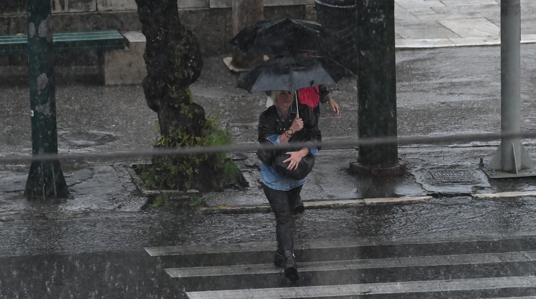 Πολίτες με ομπρέλες εν μέσω καταιγίδας