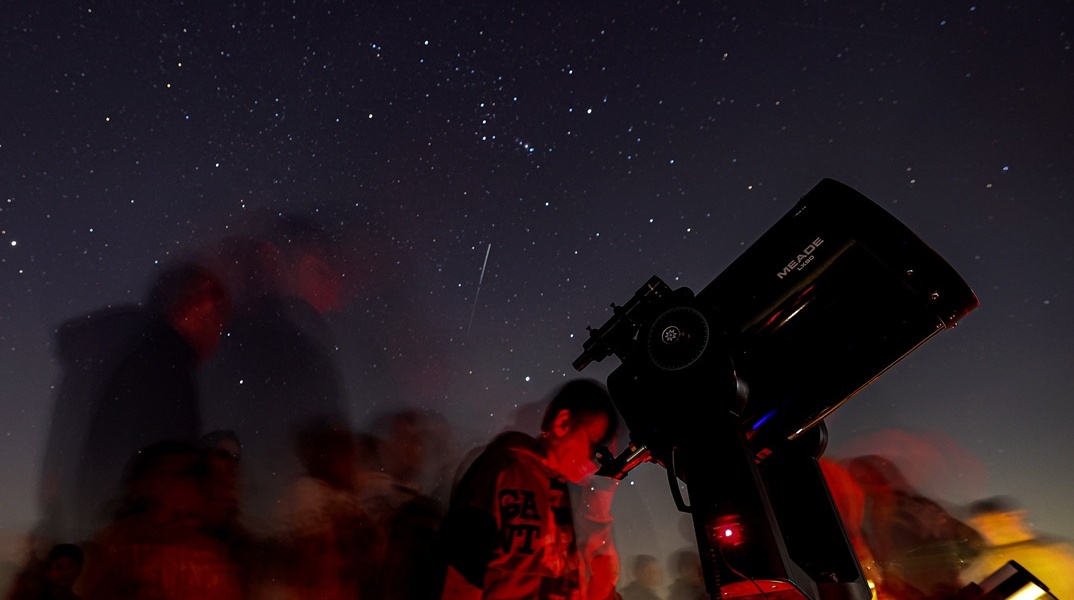 Πολίτες στον νυχτερινό ουρανό δίπλα σε τηλεσκόπιο για την παρακολούθηση πλανητών