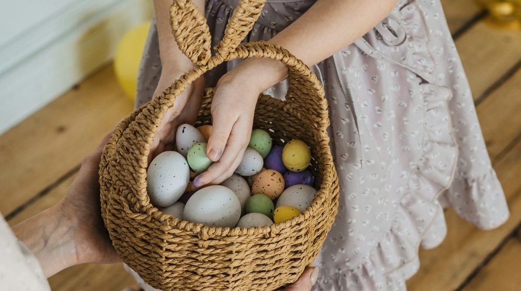 Κοριτσάκι βγάζει αυγά από πασχαλινό καλαθάκι
