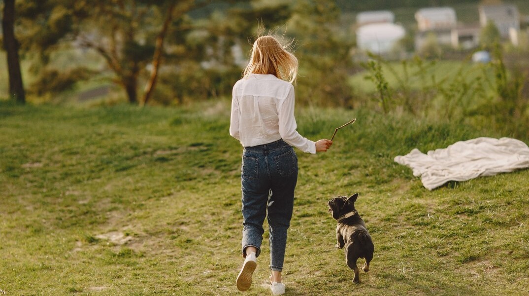 Γυναίκα βγάζει βόλτα τον σκύλο στην εξοχή
