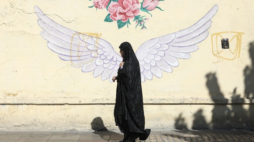 Γυναίκα περνά μπροστά από mural στην πρωτεύουσα του Ιράν, Τεχεράνη