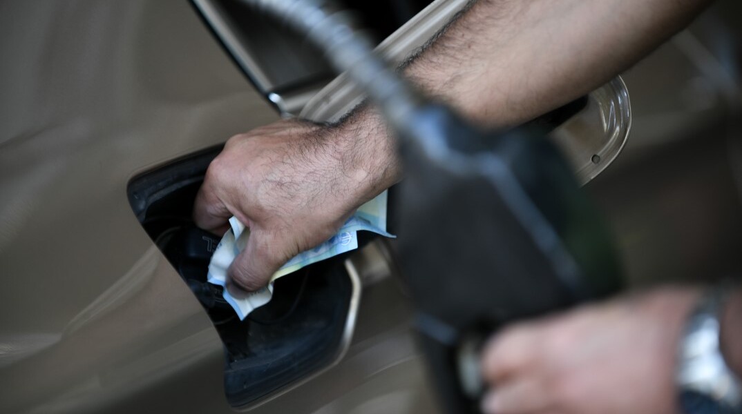 Υπάλληλος σε πρατήριο υγρών καυσίμων βάζει βενζίνη σε αυτοκίνητο