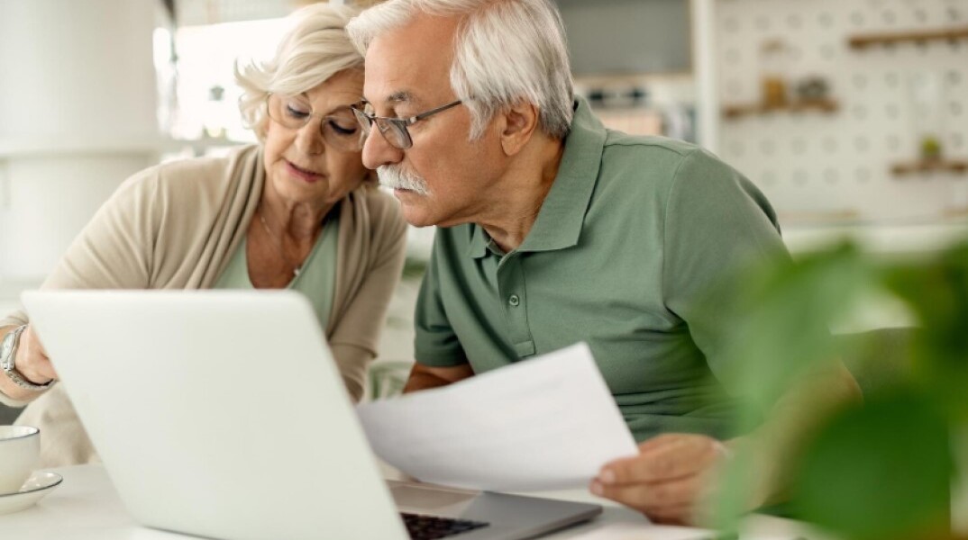 Συνταξιούχοι κοιτούν στον υπολογιστή για τα αναδρομικά και την πληρωμή τους