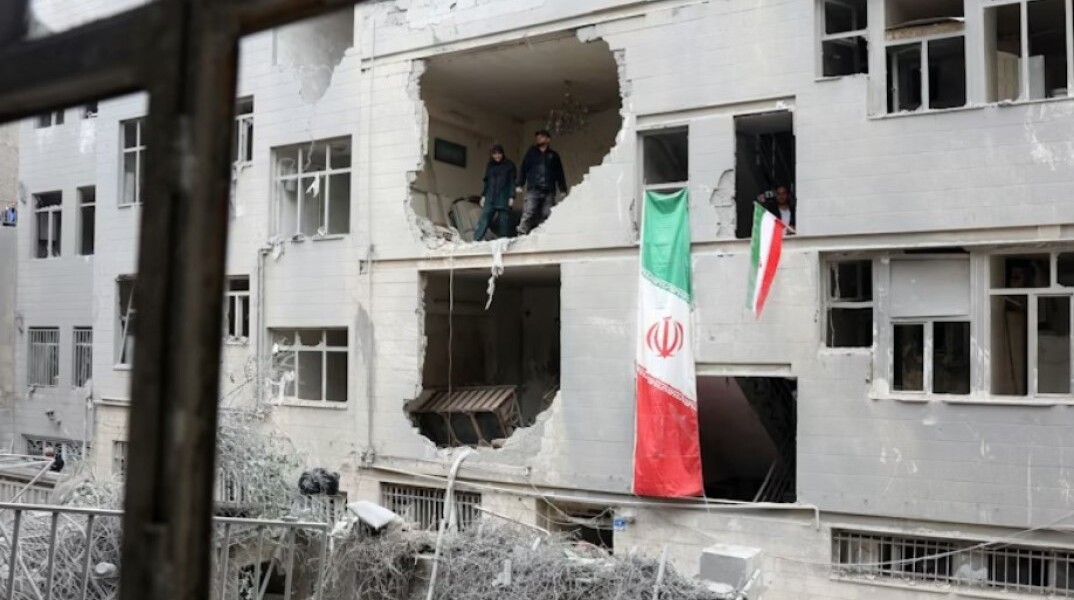 Κάτοικοι στην Τεχεράνη μέσα σε κατεστραμμένο κτίριο μετά από βομβαρδισμό των ΗΠΑ