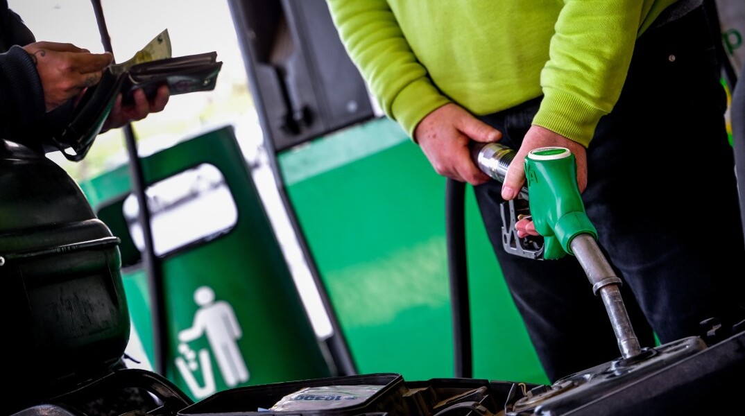 Υπάλληλος σε πρατήριο υγρών καυσίμων βάζει βενζίνη