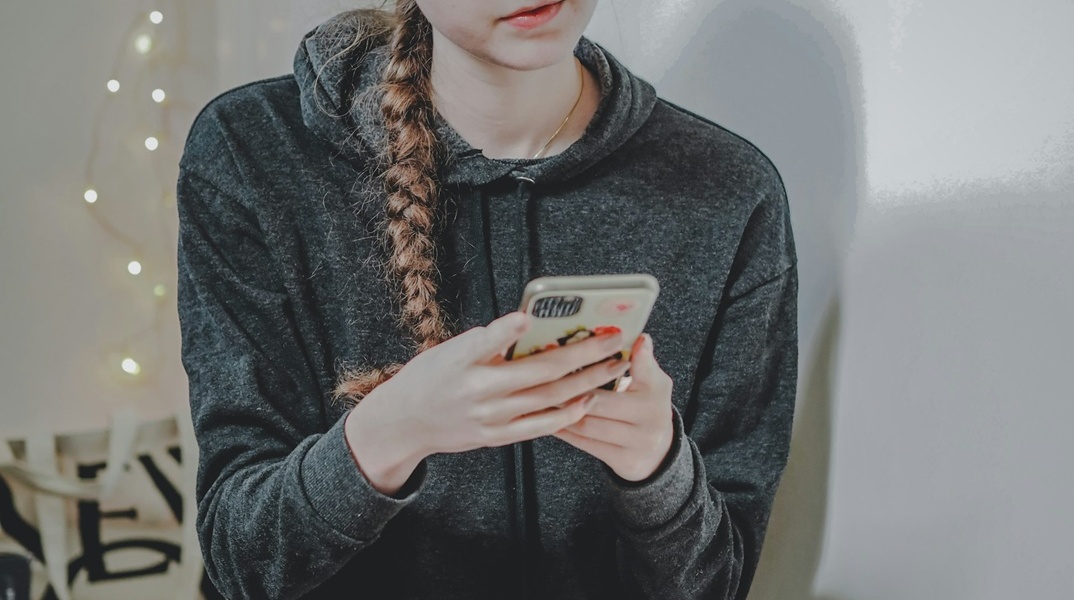 Ανήλικη με το κινητό στο χέρι