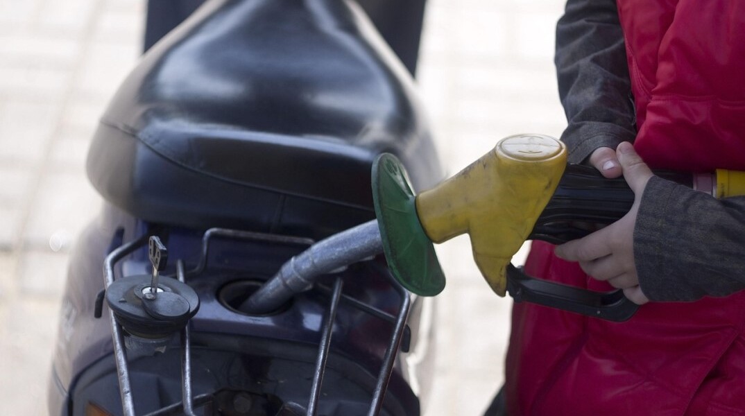Υπάλληλος σε βενζινάδικο γεμίζει με βενζίνη το ρεζερβουάρ μηχανής