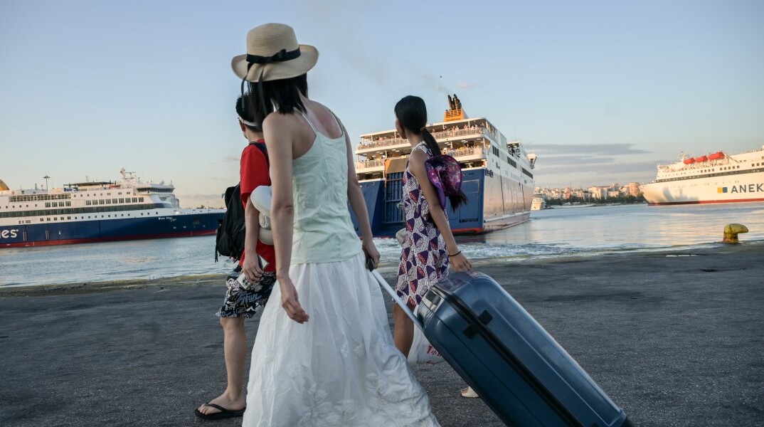 Επιβάτες στο λιμάνι του Πειραιά ετοιμάζονται να επιβιβαστούν σε πλοίο της γραμμής για νησιά του Αιγαίου