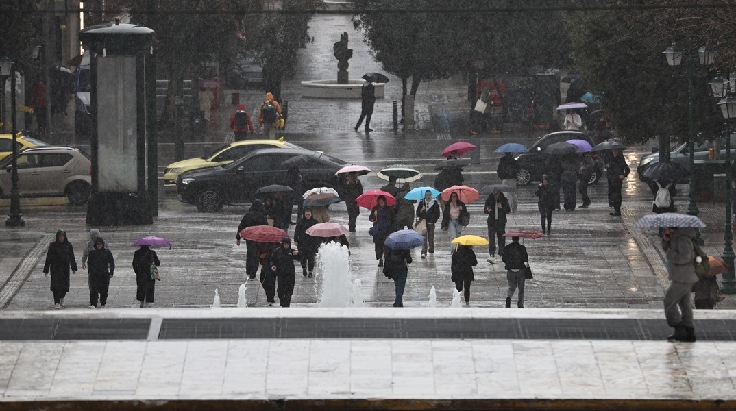 Πολίτες με ομπρέλες στην Αθήνα εν μέσω βροχής