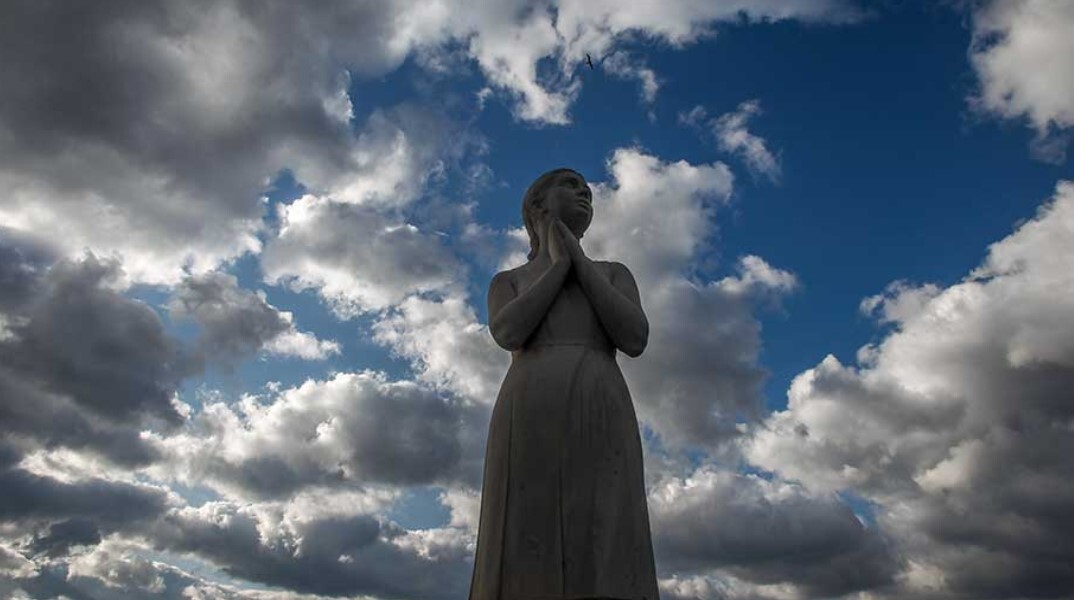 Άγαλμα με φόντο τον συννεφιασμένο ουρανό