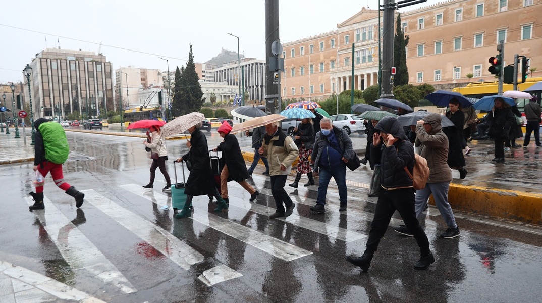 Πολίτες στο κέντρο της Αθήνας εν μέσω καταιγίδας