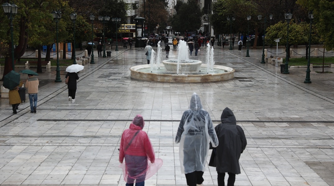 Πολίτες με αδιάβροχα στην πλατεία Συντάγματος