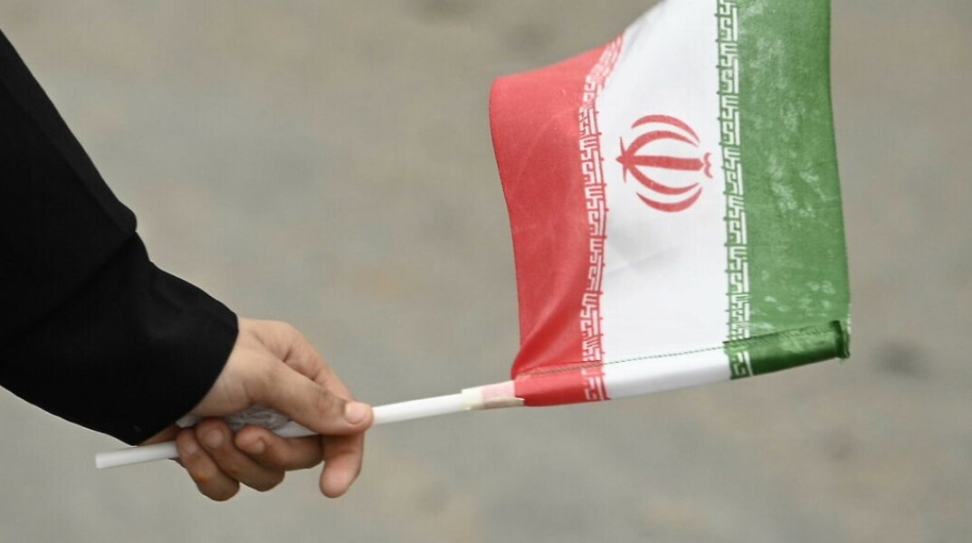 Γυναικείο χέρι κρατά σημαία του Ιράν