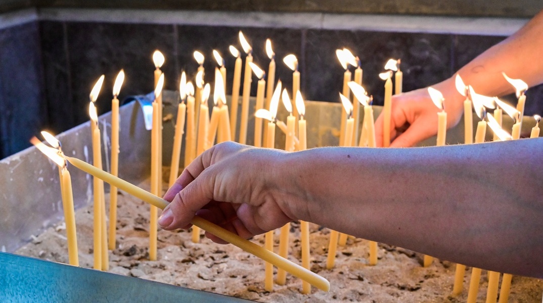 Χέρι που ανάβει κερί στην εκκλησία