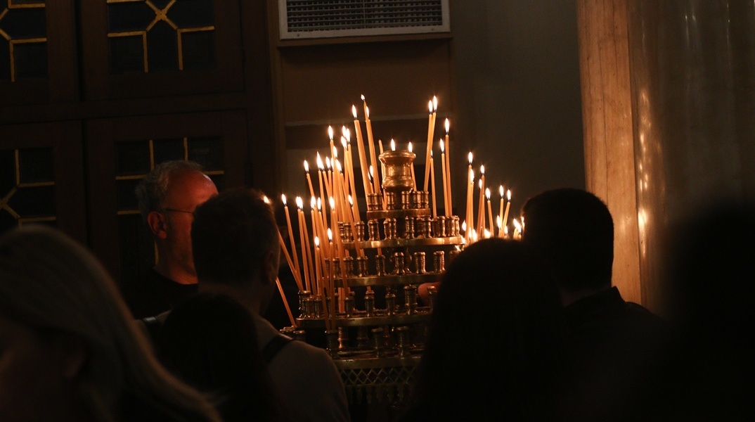 Πολίτες ανάβουν κερί στην εκκλησία