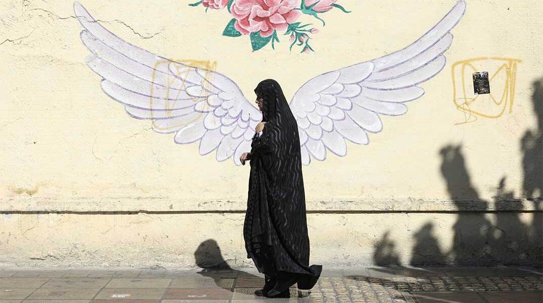 Γυναίκα περνά μπροστά από mural στην πρωτεύουσα του Ιράν, Τεχεράνη