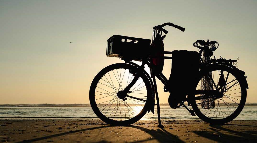 Ποδήλατο στην αμμουδιά με φόντο το ηλιοβασίλεμα