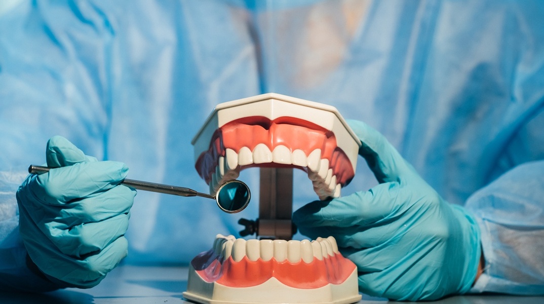 Οδοντίατρος κρατά στα χέρια του οδοντοστοιχία