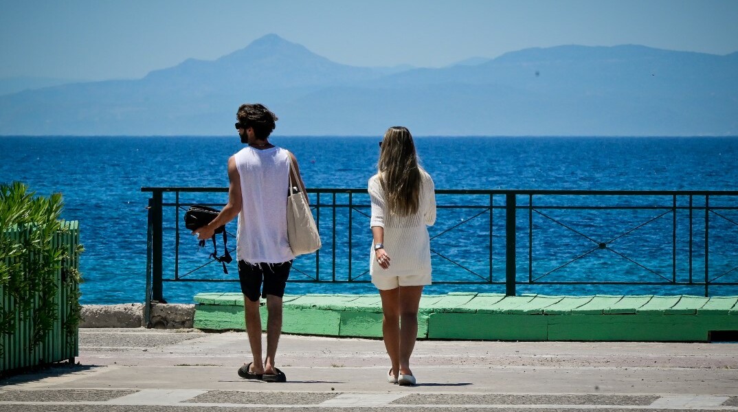 Ζευγάρι πηγαίνει για μπάνιο σε παραλία