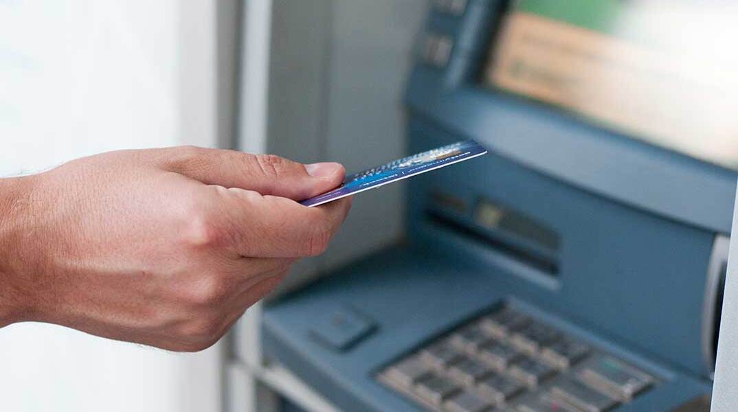 Άνδρας ετοιμάζεται να βάλει την κάρτα στο ΑΤΜ