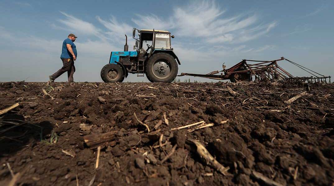 Ουκρανός αγρότης στη Ζαπορίζια κατευθύνεται στο τρακτέρ του μέσα σε χωράφι σιτηρών