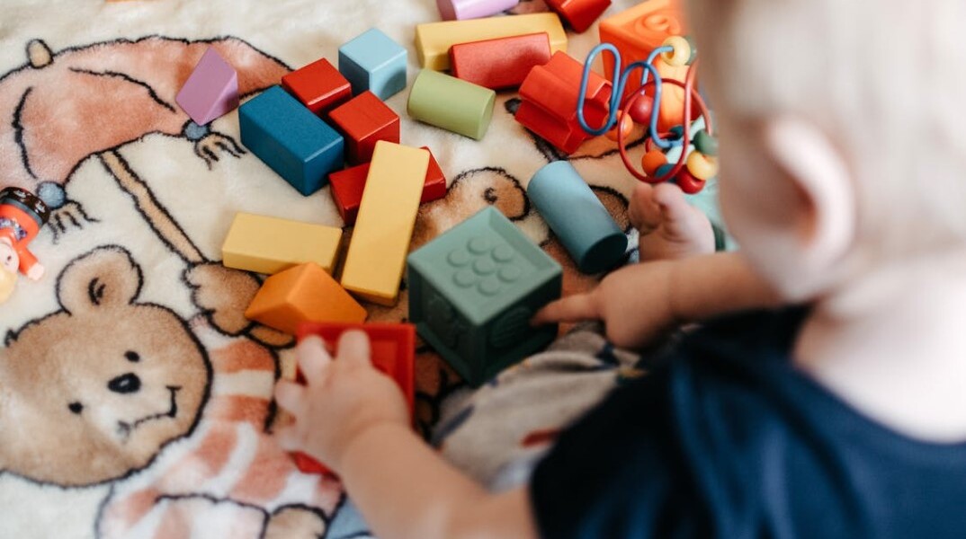 Παιδί παίζει με παιχνίδια στο πάτωμα