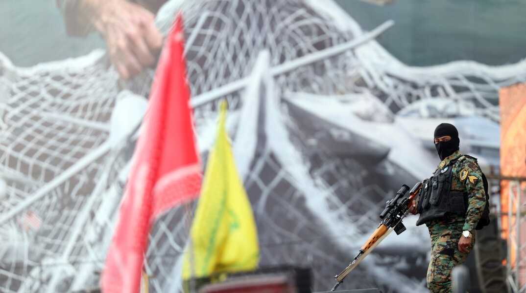 Ιρανός στρατιώτης στην Τεχεράνη με φόντο mural για τα Στενά του Ορμούζ