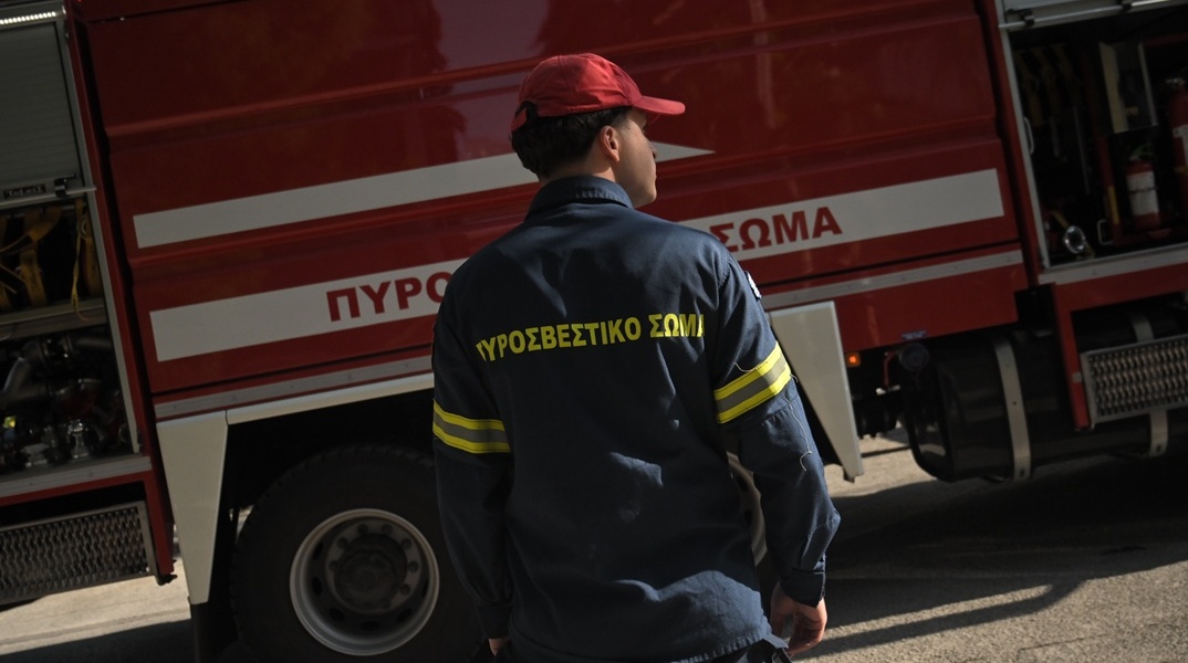Πυροσβέστης μπροστά από όχημα