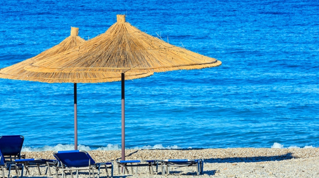 Παραλία με ξαπλώστρες και ομπρέλες