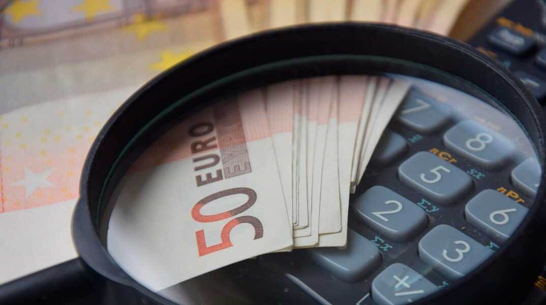Χαρτονομίσματα του ευρώ, μεγεθυντικός φακός και κομπιουτεράκι υπολογισμού