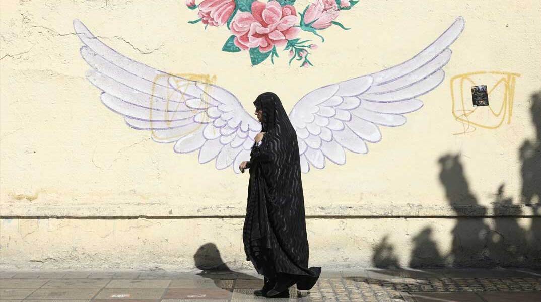 Γυναίκα περνά μπροστά από mural στην πρωτεύουσα του Ιράν, Τεχεράνη
