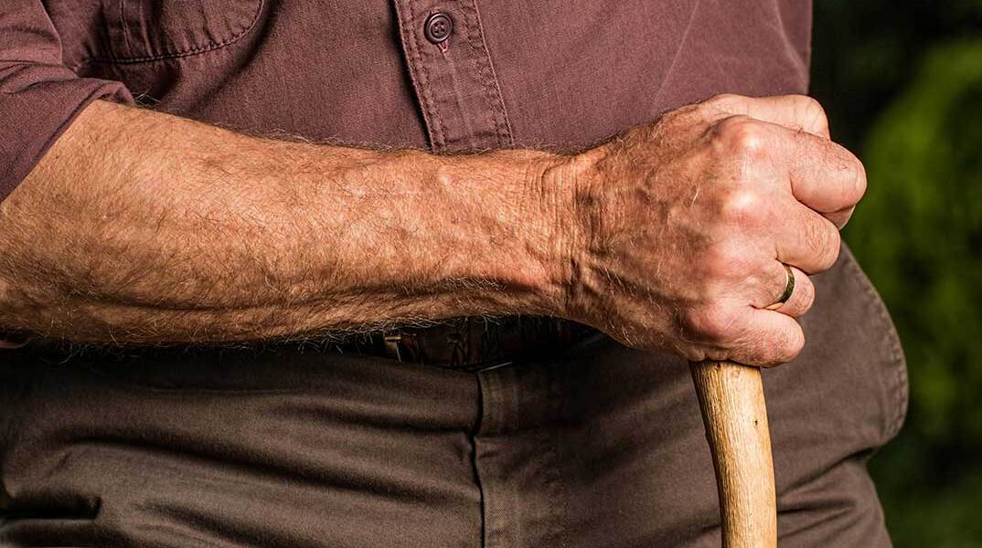 Ηλικιωμένος κρατά μαγκούρα στο χέρι