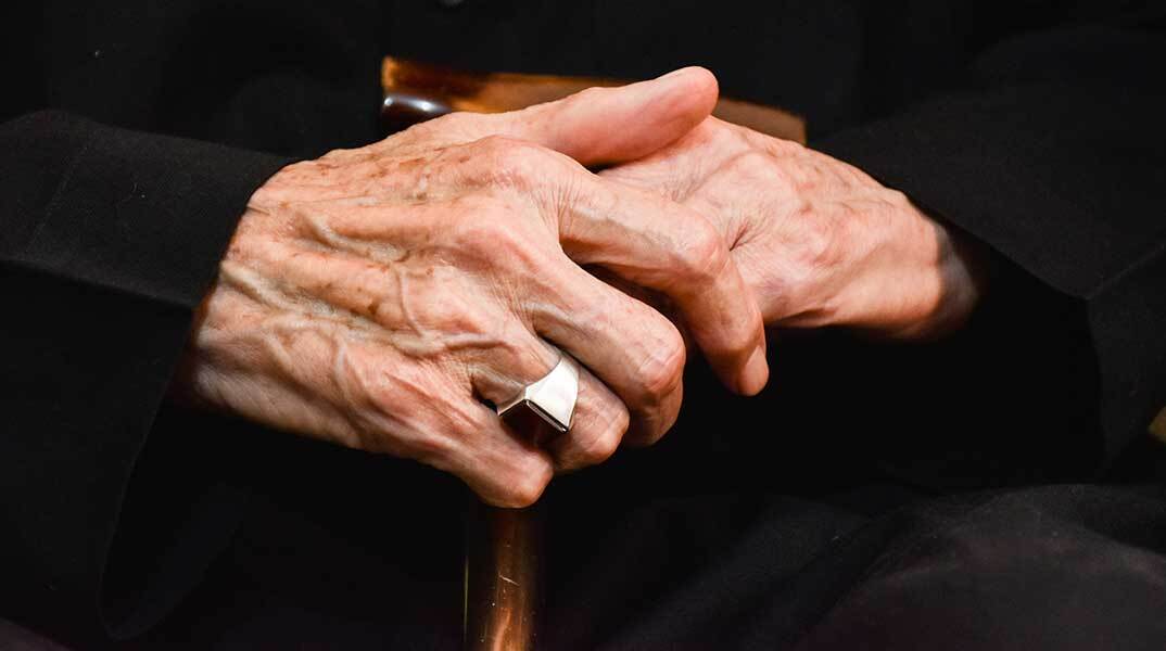 Χέρια ηλικιωμένης ακουμπισμένα σε μαγκούρα