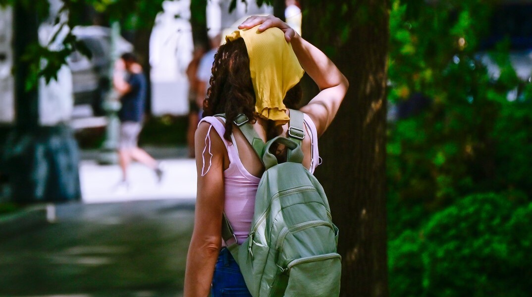 Τουρίστρια προσπαθεί να προστατευτεί από τη ζέστη στην Αθήνα