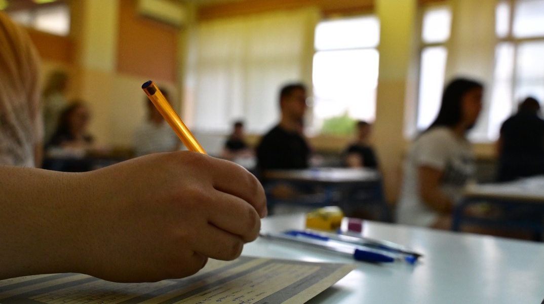 Εξεταζόμενος των πανελληνίων γράφει στο τετράδιο απαντήσεων 